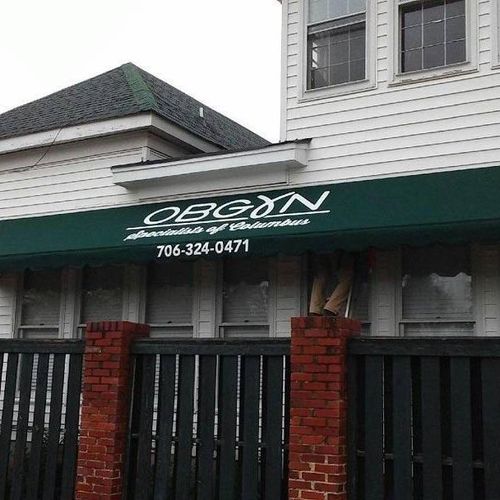 Large storefront awning that reads 'OBGYN - Specialists of Columbus - 706-324-0471'