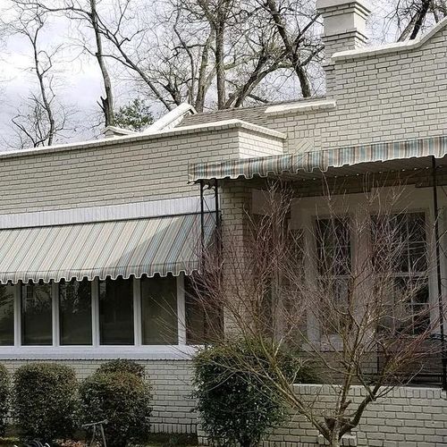 A patio cover and long window awning on the side of a home