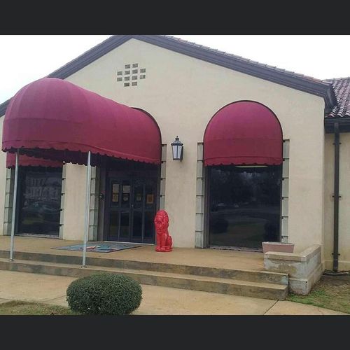 A walkway and two fabric window awnings at the entrance of a business