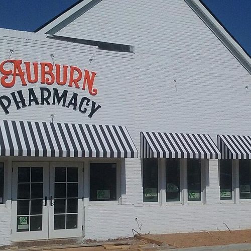 The Auburn Pharamcy building with several window awnings and a doorway awning.