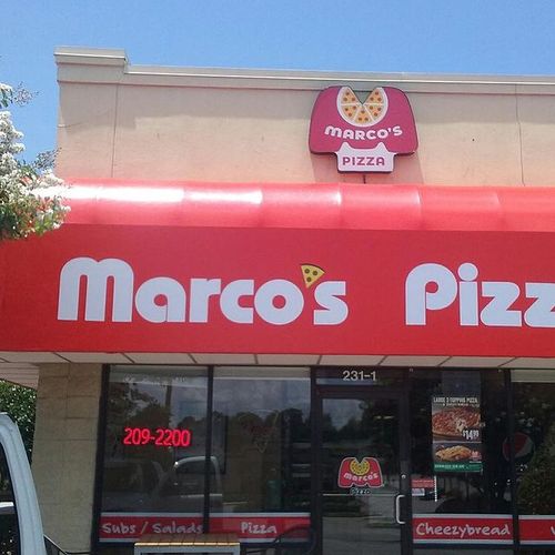 A storefront awning spans the entrance to a Marcos Pizza building