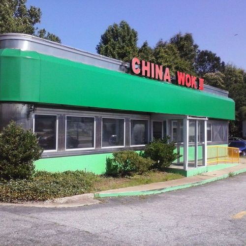 A large storefront awning wraps around a building that reads 'China Wok II'