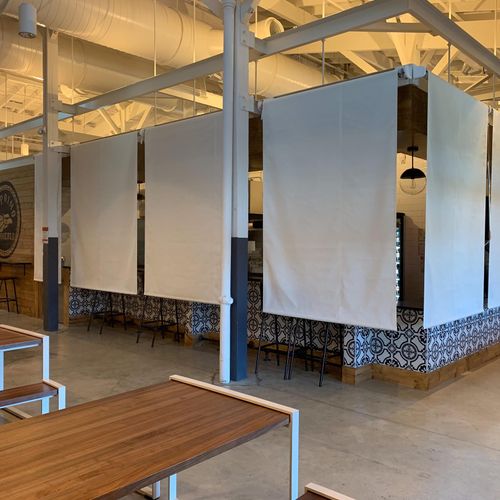 Several canvas privacy curtains hide the bar and several stools of El Primo Taqueria