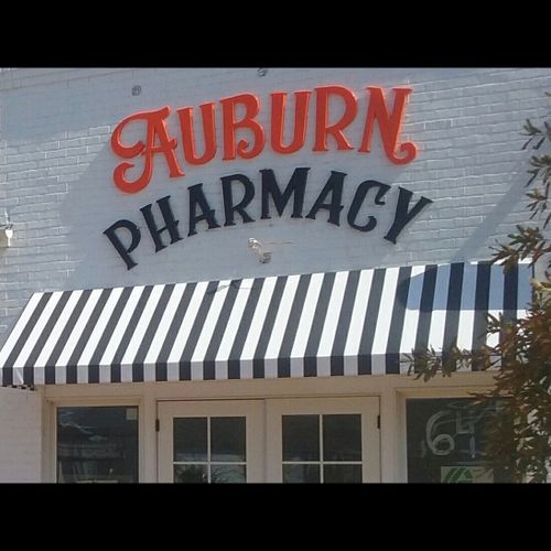 The Auburn Pharamcy building with a striped awning over its entrance