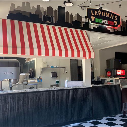 A striped interior awning covers the counter of Lepoma's Pizzeria