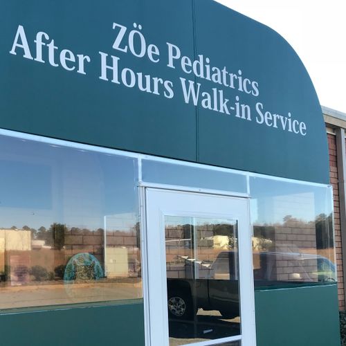 A large canvas structure covers the walkway to Zoe Pediatrics After Hours Walk-In Service building