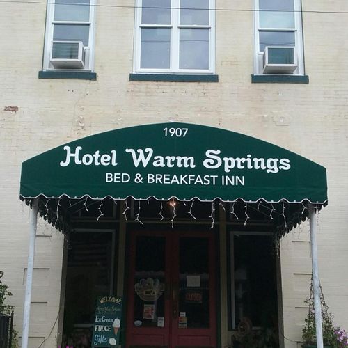 A large storefront canopy reads '1907 - Hotel Warm Springs - Bed & Breakfast Inn'