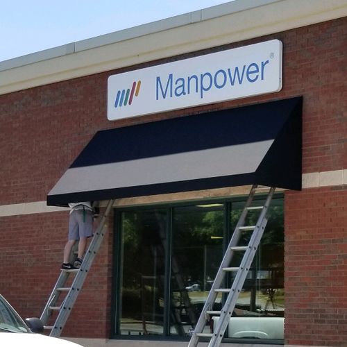 A door awning shades the doorway of the Manpower building