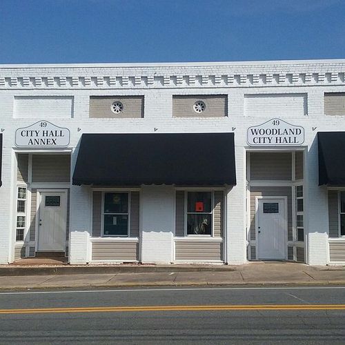 Several large window awnings shade the windows of the Woodland City Hall and City Hall Annex building