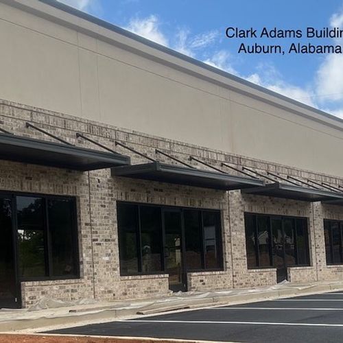 Several metal awnings shade the entrance to a commercial building