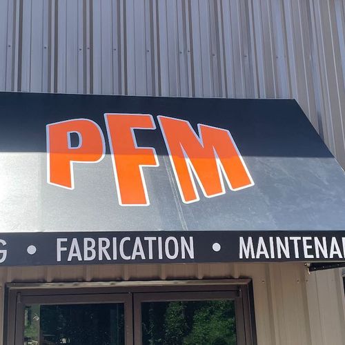 An awning covering the entrance to a commercial building reads PFM - Piping - Fabrication - Maintenance