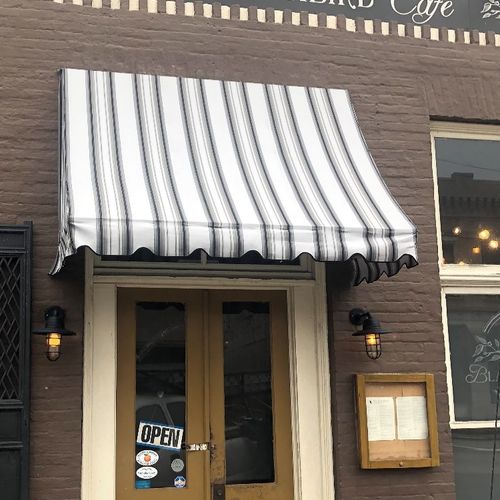 A standard canvas awning with valence covers the entrance to the Blackbird Cafe