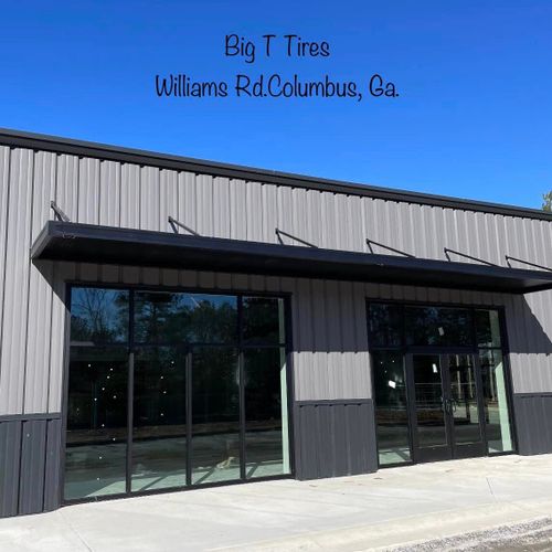 Metal awnings cover various entrances to the Big T Tires building in Columbus