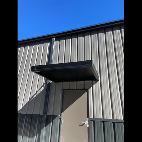 Metal awnings cover various entrances to the Big T Tires building in Columbus