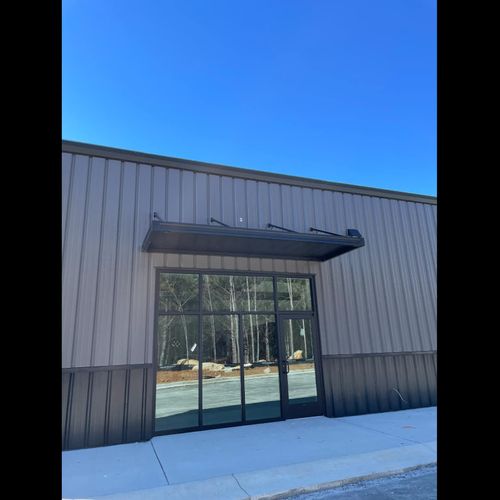 Metal awnings cover various entrances to the Big T Tires building in Columbus