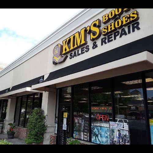 Several awnings cover storefront windows for Kim's Boot & Shes - Sales & Repair