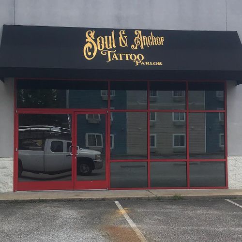 A fabric storefront awning reads 'Soul & Anchor Tattoo Parlor'