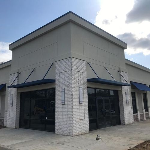 Several awnings cover the doorways and windows of an unlabeled commercial building