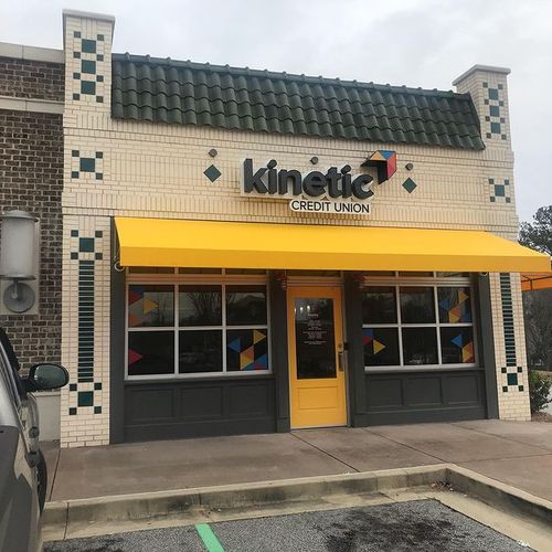 A storefront awning shades the doorway to the Kinetic Credit Union building