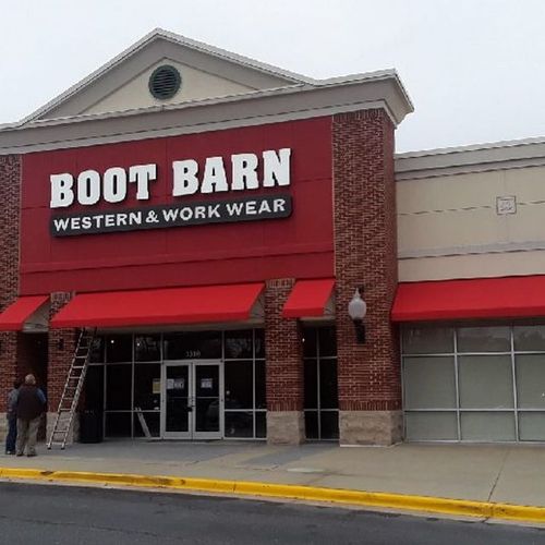 Several awnings over various doors and windows of the 'Boot Barn - Western & Work Wear' building