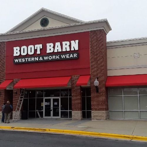 Several awnings over various doors and windows of the 'Boot Barn - Western & Work Wear' building