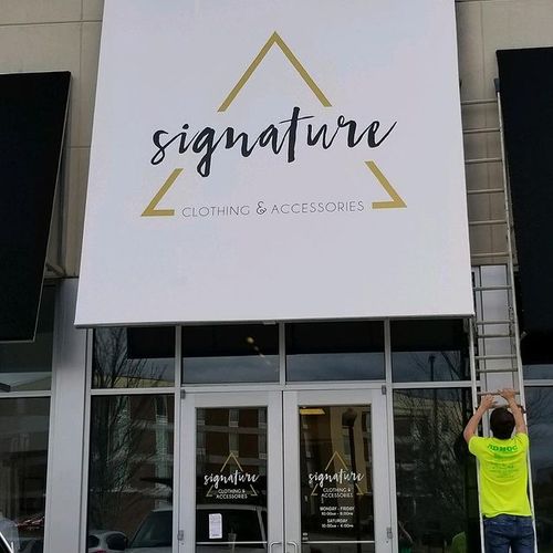 A tall awning covers the entrance to the 'Signature - Clothing & Accessories' building
