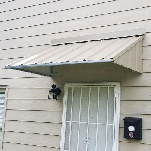 A small metal door awning covers the entrance to a house